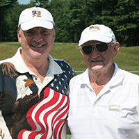 Bruce Mitchell and Charles J. Smith ’55 share a round of golf.