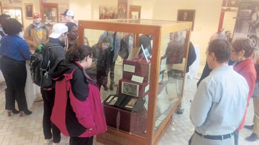 Students in Ian Delahanty’s Making History Public class unveil a new exhibit in the Springfield College Museum showcasing their research on the school’s involvement in World War I.