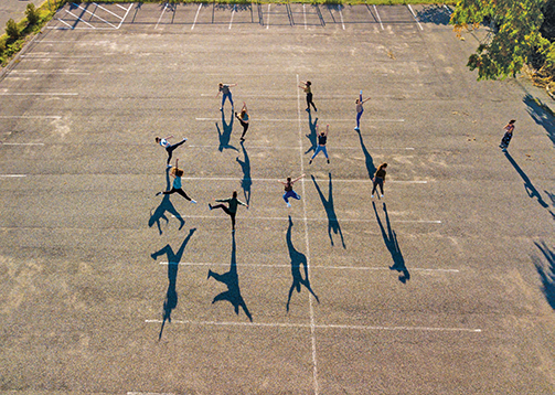  A dance class rehearses in a campus parking lot