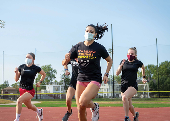 female track athletes running with masks