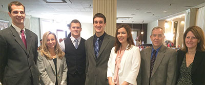 Students from the business administration program at the Super 60 luncheon with College faculty members and administrators.