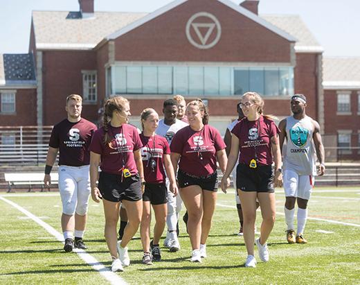 Strength and conditioning coaches with some members of the football team